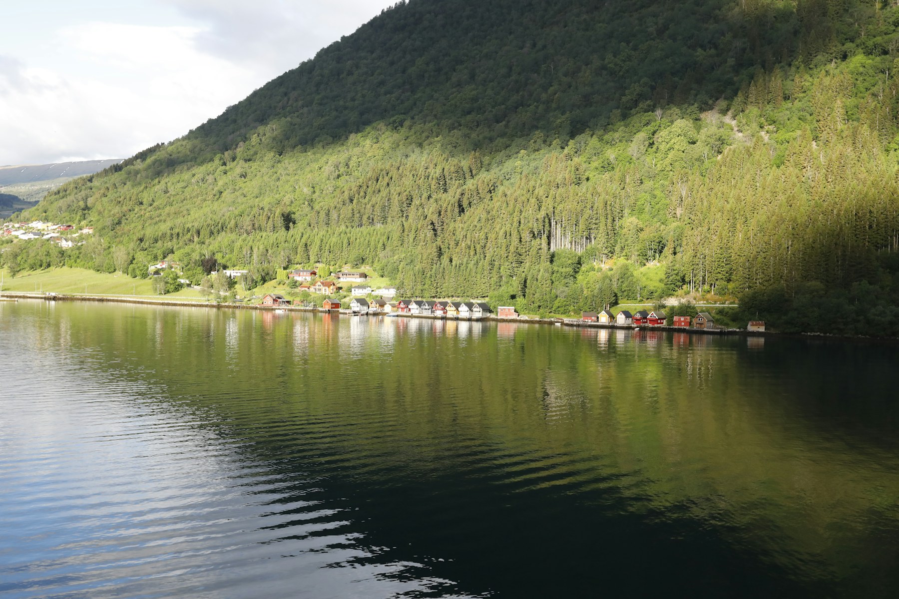 Still northern fjord reflecting snowy mountains