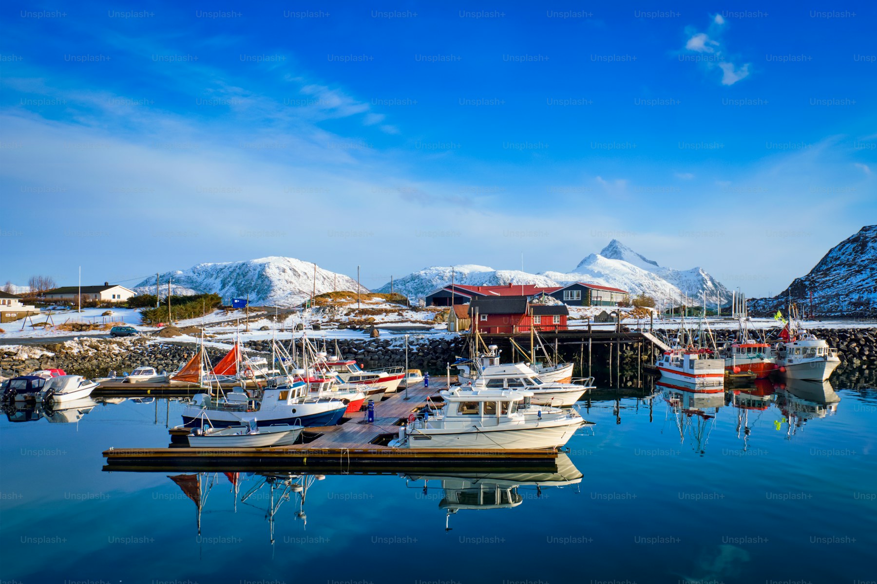 Fishing boats moored in a snow-covered Norwegian fjord